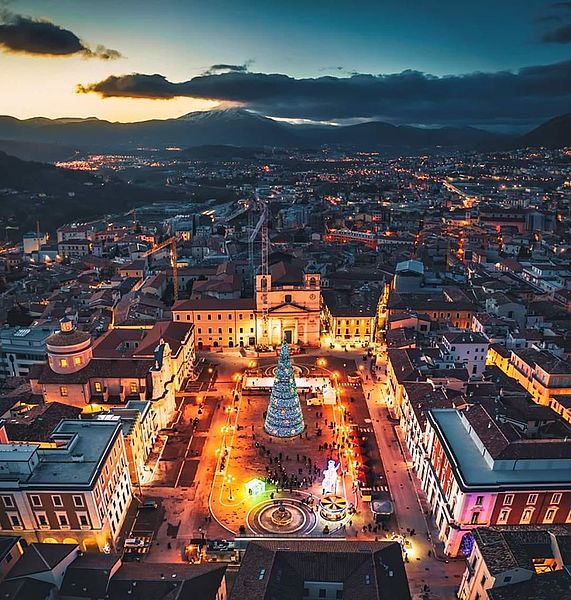 Aerial view of the main square in L'Aquila at dusk.